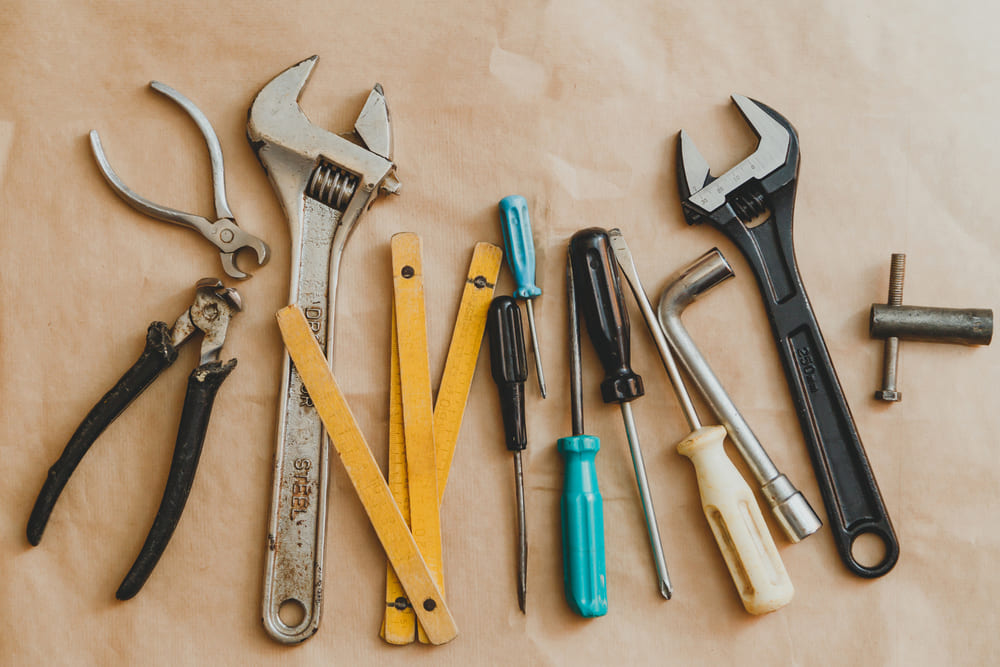 A variety of tools are laid out on a brown paper.